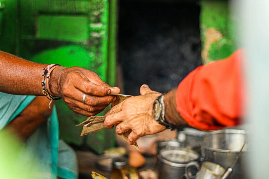 Street food vendor in India accepting cash from tourists