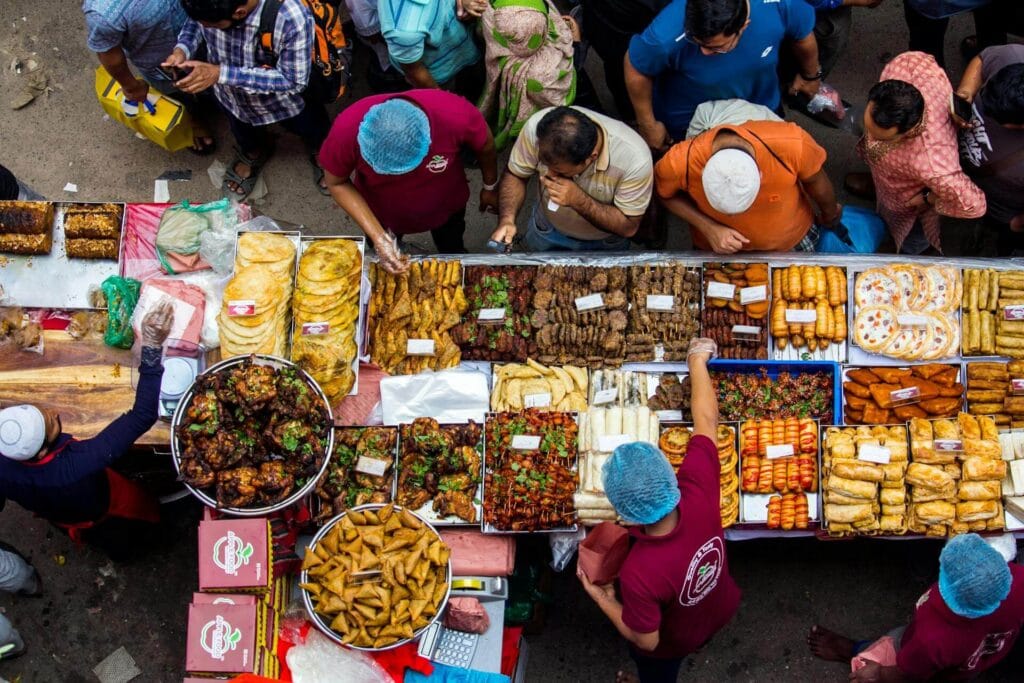 People enjoying street food at a busy market in India